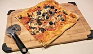 Pizza fatta in casa con crosta gommosa, evidenziando la consistenza e la farina utilizzata.