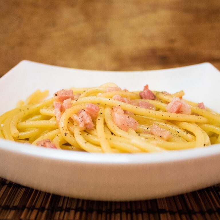 Piatto di carbonara cremoso, preparato senza panna, con guanciale e pecorino.