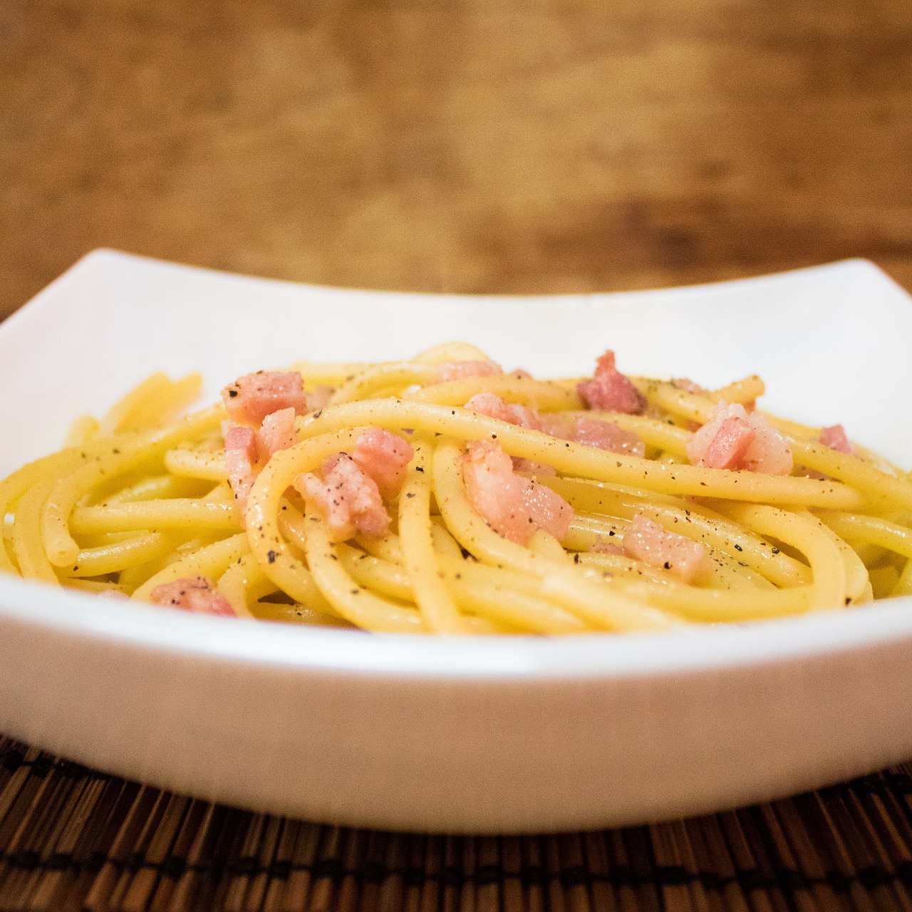 Piatto di carbonara cremoso, preparato senza panna, con guanciale e pecorino.