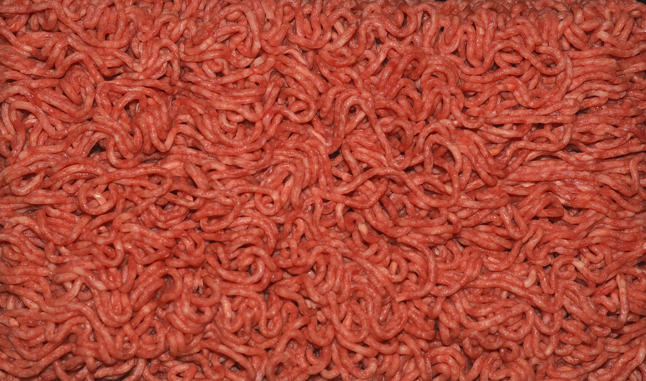 Immagine di carne macinata in vaschetta con colorazione grigia sul fondo.