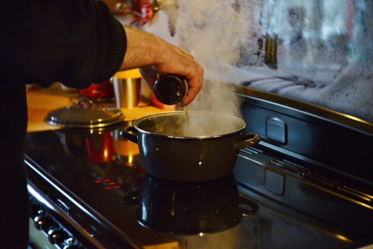 Cucina con il vino: pentola sul fuoco mentre l'alcol evapora prima di coprire.