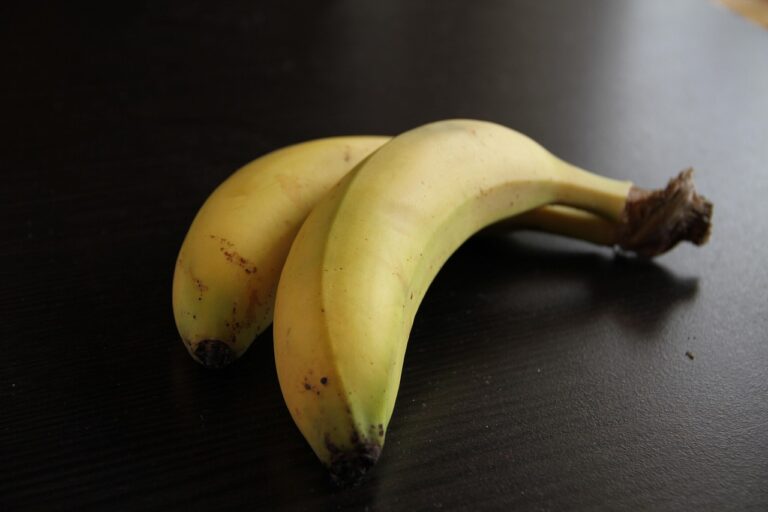 Banane con picciolo avvolto in pellicola trasparente per una conservazione prolungata.
