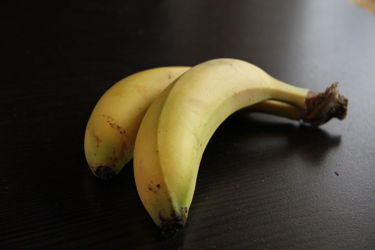 Banane con picciolo avvolto in pellicola trasparente per una conservazione prolungata.