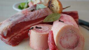 Brodo di carne in una pentola, ingredienti freschi e aromi sul tavolo, ricetta della nonna.