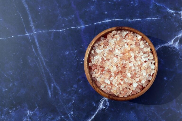 Confronto tra sale rosa dell'Himalaya e sale marino su sfondo neutro.